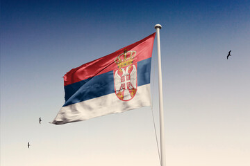 Serbia flag fluttering in the wind on sky.