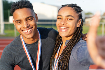 Portrait of male and female athlete celebrating with medals - obrazy, fototapety, plakaty