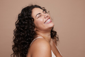 Studio shot of smiling young woman with curly hair