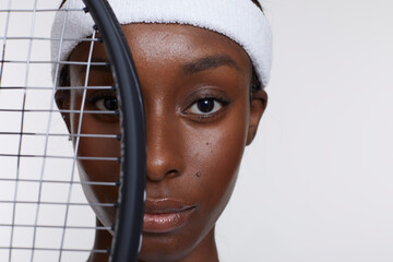 Studio portrait of athletic woman with tennis racket