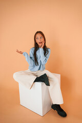 Feeling confused. Cute young girl is in the studio against background