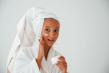 Cream for the face skin. Conception of beauty and self care. Young girl is in the studio