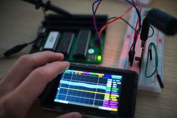 Technical Expertise: A Microcontroller Undergoes Repair with Precision Tools and a Breadboard
