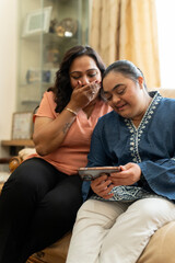 Woman with down syndrome daughter using smart phone at home