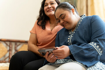 Woman with down syndrome daughter using smart phone at home