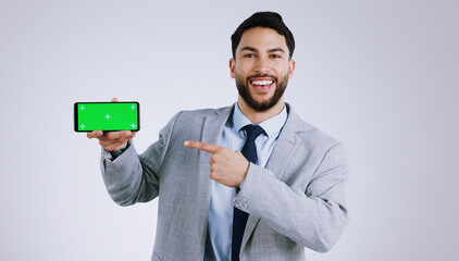 Business man, mobile green screen and presentation for social media, career software or job registration in studio. Portrait of corporate worker pointing to phone app or mockup on a white background