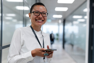 Non binary office worker standing in corridor