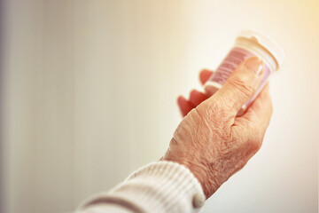 Medicine, woman and hands with a bottle of pills for recovery, health and wellness. Healthcare, medication and closeup of a senior female person with prescription tablets, supplements or vitamins.