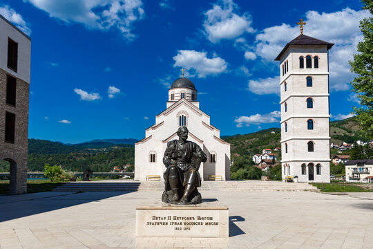 Visegrad, Republic of Srpska, Bosnia and Herzegovina - August 13, 2023: St. Lazar Church in Andricgrad and a monument to Petar II Petrovic Njegos. Construction project by film director Emir Kusturica.