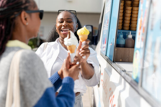 Young female friends buying ice cream in ice cream truck