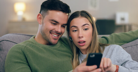 Reading, phone and couple on sofa for social media, internet and browse website together. Dating, home and man and woman on smartphone for online chat and bonding, relax and love in living room