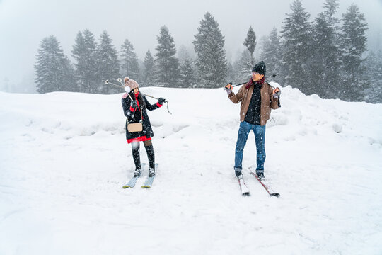 Asian tourist couple on ski and snow of Sonmarg Valley in Himalayas during winter Christmas trip, honeymoon vacation, lover romantic journey. Weather white and snowing. Sonamarg, Jammu, Kashmir, India