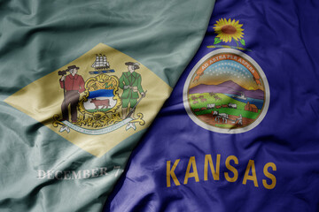 big waving colorful national flag of kansas state and flag of delaware state .