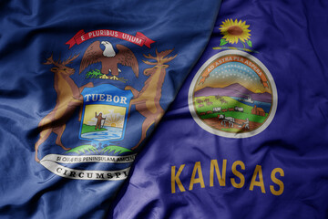 big waving colorful national flag of kansas state and flag of michigan state .