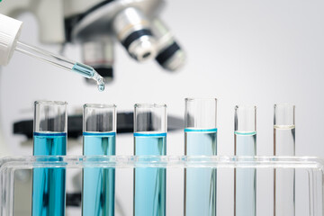 Chemistry laboratory tube glass, science laboratory research and development concept, flask, beaker, and test tubes with dropping blue liquid water sample test, scientific test tubes equipment. - obrazy, fototapety, plakaty