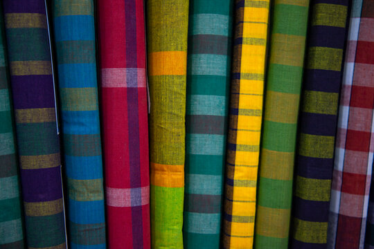 Multicolor Traditional Bangladeshi men's wear lungi folded on a rack in a store. Can be used as  pattern texture background wallpaper