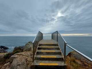 an empty pier with a view of the ocean and sky