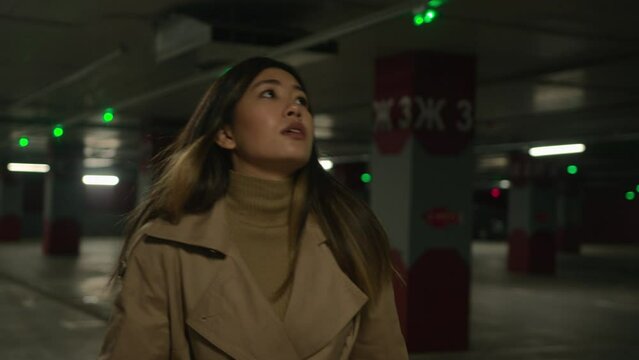 Lonely scared frightened terrified Asian woman stressed chinese korean japanese girl victim need help scary alone in dark car parking running looking around fear dangerous threat afraid pursuit horror