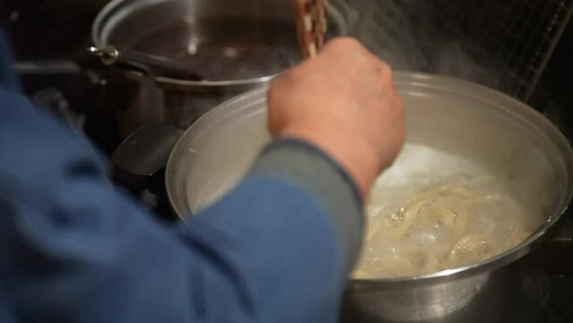 蕎麦を茹でる女性