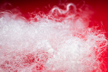 Extreme macro of polyester stable fiber on red background