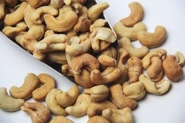 Close-up of roasted cashew nuts (Anacardium occidentale) on a white background. View from above. Native of Brazil. Rich in magnesium, iron, zinc, selenium, vitamin A, E and antioxidants.