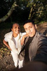 Portrait of smiling couple taking selfie in forest