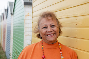 Portrait of smiling senior woman standing by beach hut