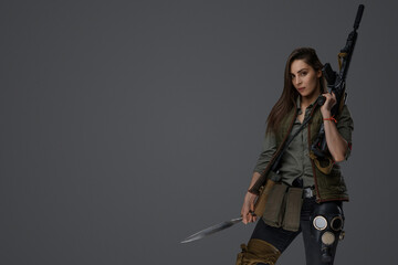 Middle Eastern woman, dressed in post-apocalyptic survivalist gear, poses with a dagger and an...