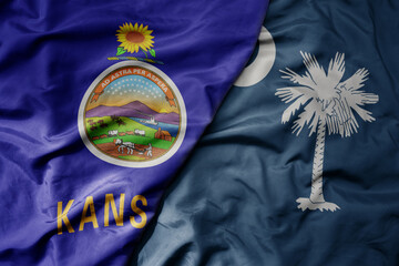 big waving colorful national flag of south carolina state and flag of kansas state .
