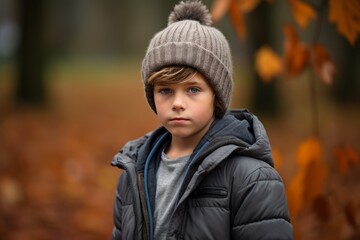 Portrait of a boy in a hat and jacket in the autumn forest