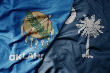 big waving colorful national flag of south carolina state and flag of oklahoma state .
