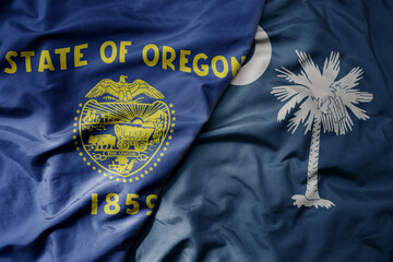 big waving colorful national flag of south carolina state and flag of oregon state .