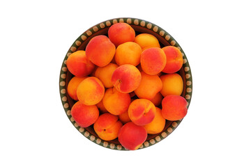 Apricots in a clay plate isolated on white background. Ripe apricots in rustic bowl.
