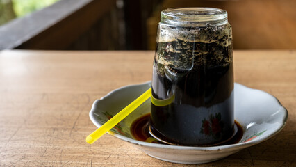 a unique black coffee drink that is served upside down and drunk through a straw