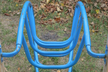 part of a blue metal staircase in a structure on a playground on the street