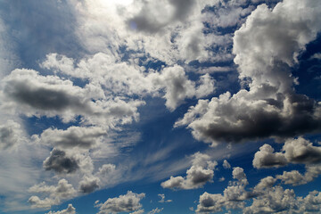 Cumulus clouds in a blue sky illuminated by the sun