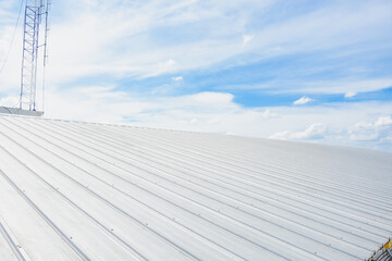 metal sheet roofing on commercial construction with blue sky - Powered by Adobe