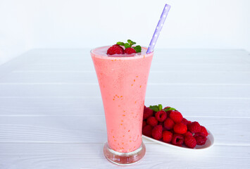 Raspberry smoothie red colorful fruit juice milkshake blend beverage healthy high protein the taste yummy In glass drink episode morning on white wood background from top view.