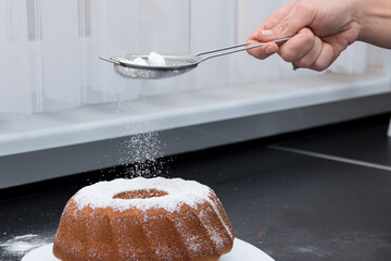 sprinkling cake with powdered sugar