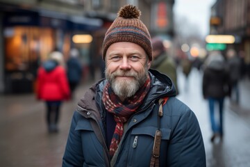 Portrait of a bearded man in a hat and coat on a city street