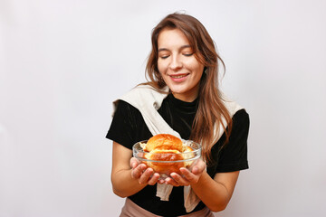 A beautiful girl holds a bowl of cakes in her hands. Housework concept.