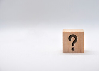 Question mark on wooden cube on white background.