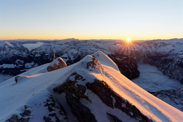 Sonnenaufgang am Watzmann Hockeck in den Berchtesgadener Alpen im Winter mit schneebedecktem Bergpanorama