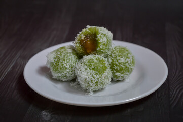 Klepon, traditional food or snack from Indonesia, made from glutinous rice flour and filled with brown sugar covered with grated coconut. Green klepon is made from pandan leaf juice.