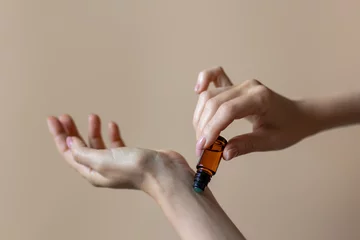 Woman applying natural rollerball aroma oil on her wrist close up  © orlio