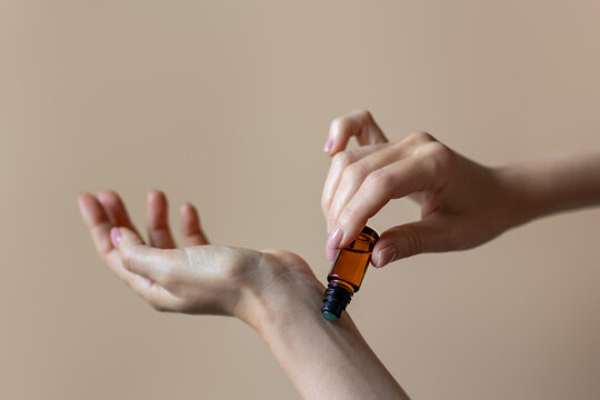 Woman applying natural rollerball aroma oil on her wrist close up	