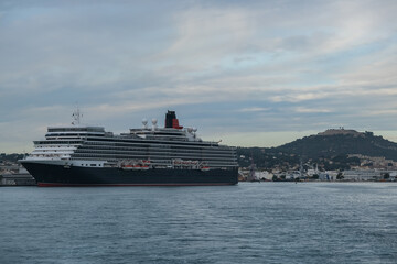 Classic british luxury ocean liner cruiseship cruise ship in port with detail view of steel hull, bow, superstructure and bridge in black, white and red color paint