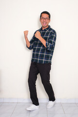 Full body portrait of a man standing with excited expression