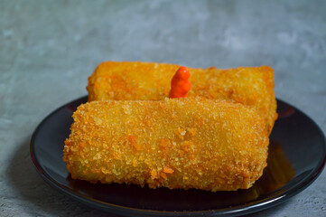 Sosis Solo is Indonesian traditional fried egg crepe with sweet and minced chicken filling. A savory snack, served with cayenne pepper or chilli sauce, available in traditional market or street food.