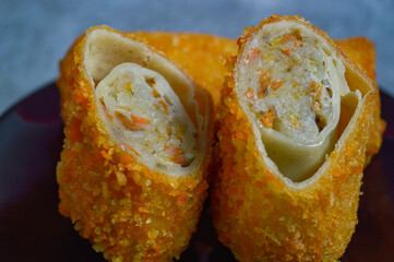 Sosis Solo is Indonesian traditional fried egg crepe with sweet and minced chicken filling. A savory snack, served with cayenne pepper or chilli sauce, available in traditional market or street food.